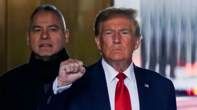 Donald Trump is seen raising his fist before he enters the New York courtroom