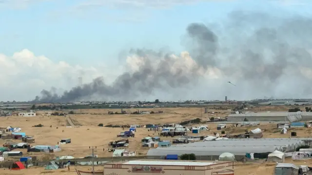 A kite flies, as smoke rises during an Israeli ground operation in Khan Younis