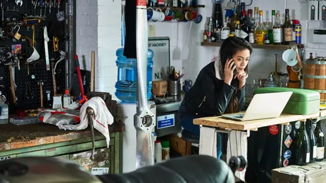 A woman stands in a mechanic shop