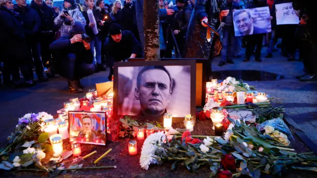 Candles and flowers sit next to the photo of Russian late opposition leader Alexey Navalny outside the Russian Embassy in Riga