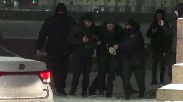 A group of policemen can be seen detaining a protester in St Petersburg