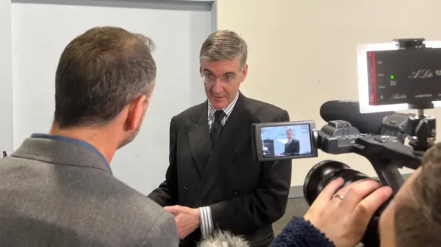 Tory MP Jacob Rees Mogg talking to a group of reporters