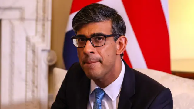 UK PM Rishi Sunak wears glasses and a blue tie