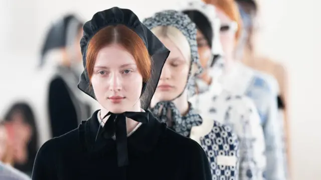 Models on the catwalk wear bonnets and frilly dresses during the Bora Aksu show at The Hellenic Centre during London Fashion Week