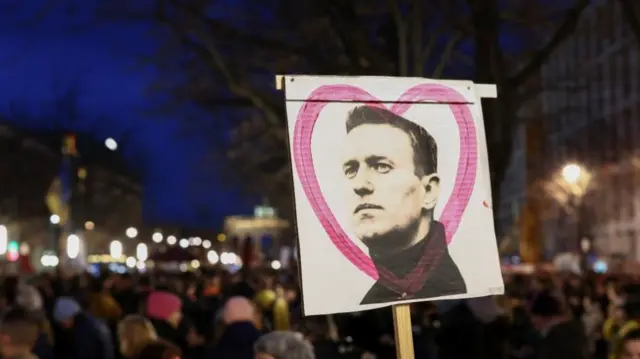 A sign with an image of Russian opposition leader Alexei Navalny is seen as people attend a vigil held in front of Russian embassy in Berlin after his death