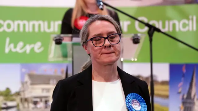 Conservative Party candidate Helen Harrison closes her eyes and she listens to the Labour candidate's victory speech