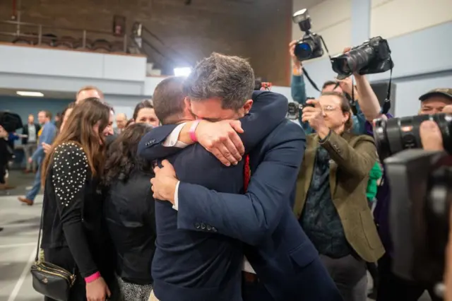 Labour MP Damien Egan hugs husband Yossi Felberbaum after being declared the new MP for Kingswood