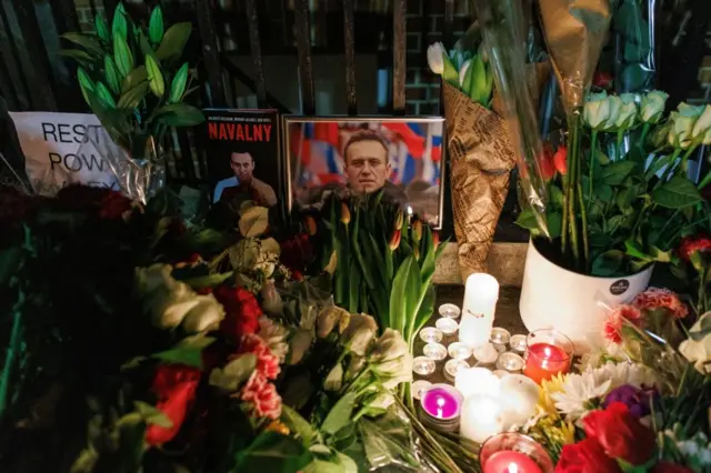 A tribute with flowers, candles and pictures to mourn Russian opposition leader Alexei Navalny outside the Russian Embassy in London