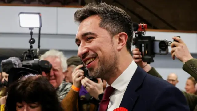 Damien Egan, the new MP in the Kingswood constituency, seen surrounded by photographers at the count