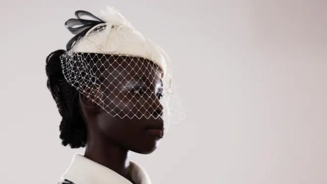 A closeup image of a model presenting a creation at the Bora Aksu catwalk show during London Fashion Week