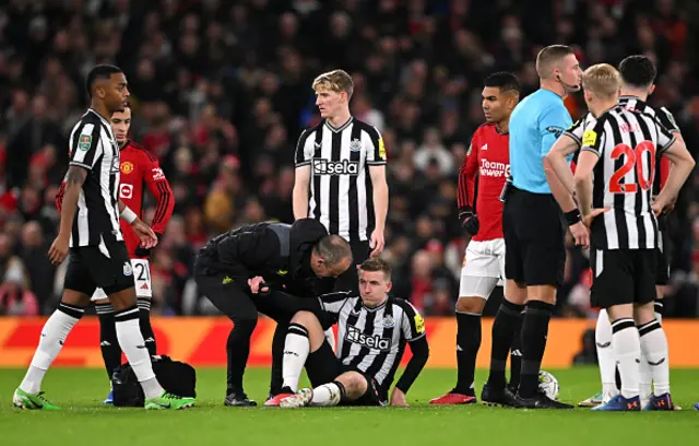 Matt Targett of Newcastle United receives medical attention
