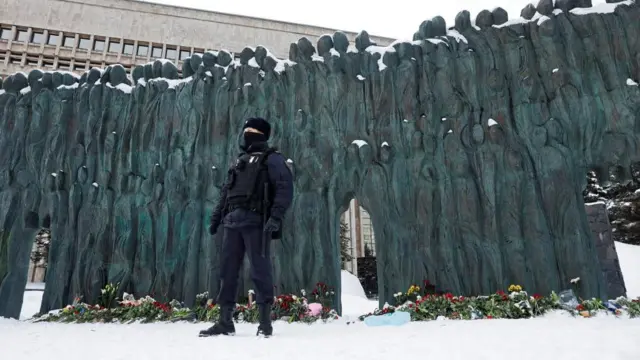 A police officer stands guard during a gathering in memory of Russian opposition leader Alexei Navalny near the Wall of Grief monument t