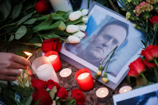 Candles next to flowers and Alexei Navalny in front of the Russian embassy in Berlin, Germany. Photo: 16 February 2024