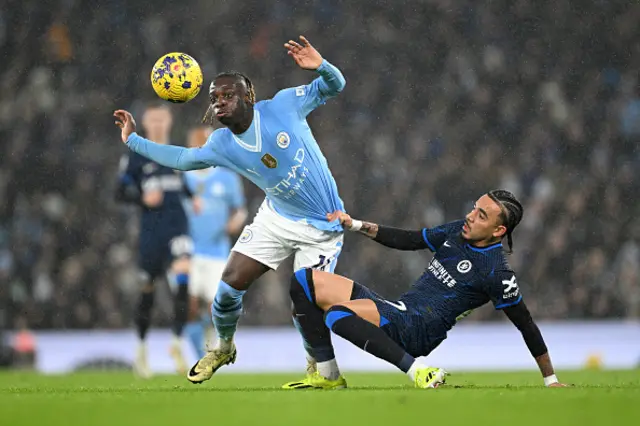 Jeremy Doku of Manchester City is challenged by Malo Gusto