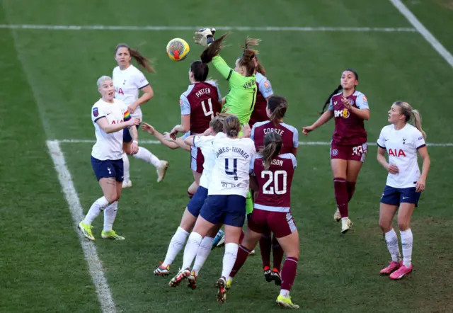 Van Domselaar punches the ball clear in a crowded penalty area.