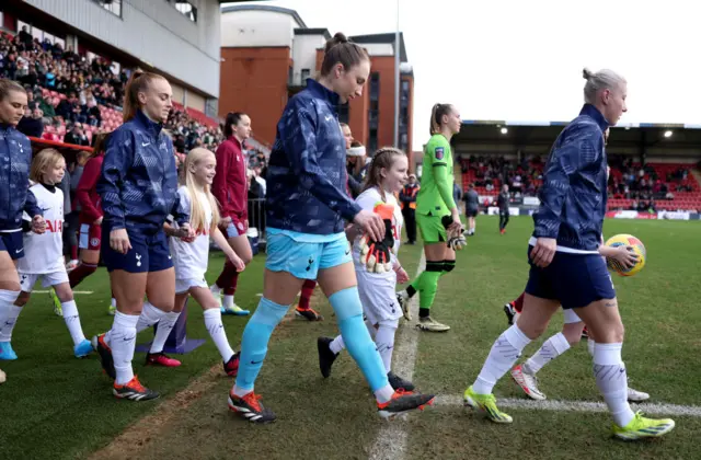 Players from both sides make their way onto the field at Brisbane road.