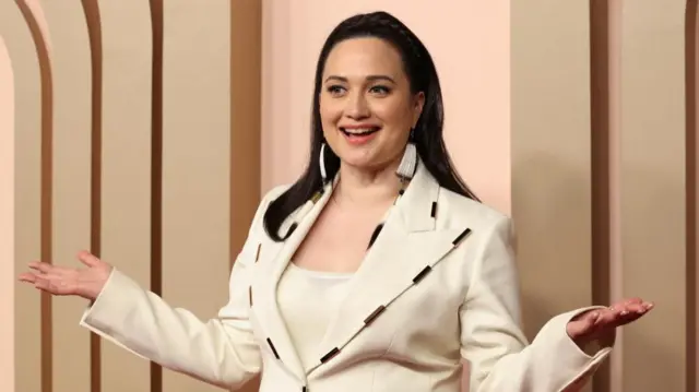 Lily Gladstone wears a white jacket at the Oscars Nominees Luncheon in Beverly Hills