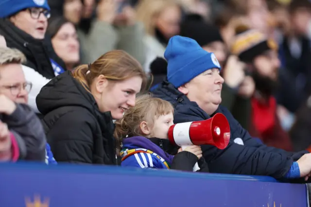 A young fan shouts support for Leicester through a megafone.