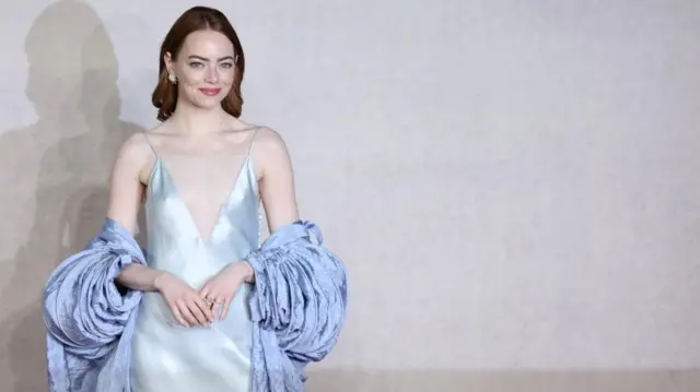 Emma Stone wearing an ice blue dress and a cornflower blue shawl