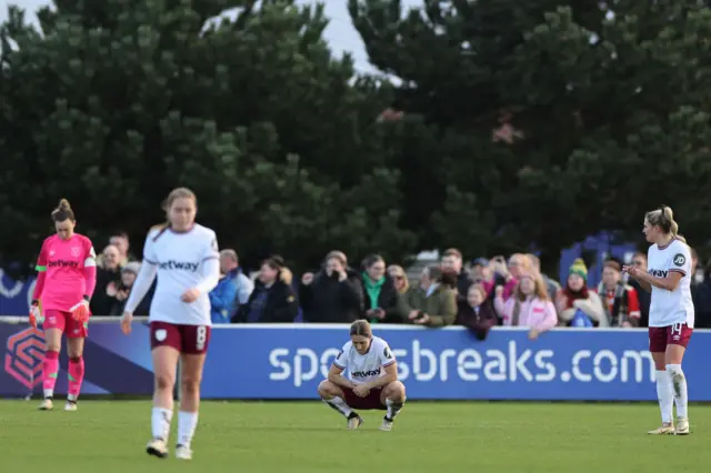 West Ham players crouch deflated after a second goal all but confirms defeat.