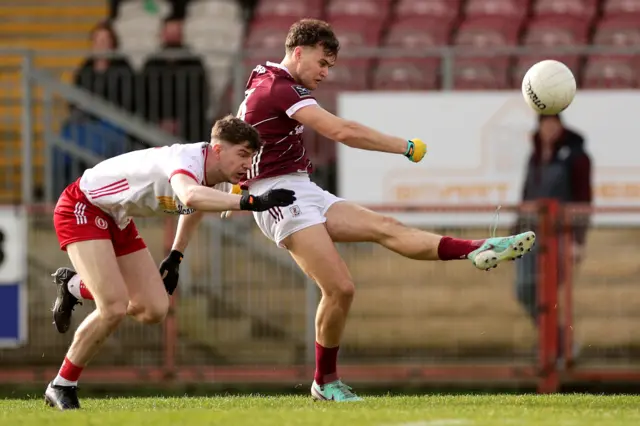 Robert Finnerty kicks his opening point at Healy Park despite Aidan Clarke's efforts