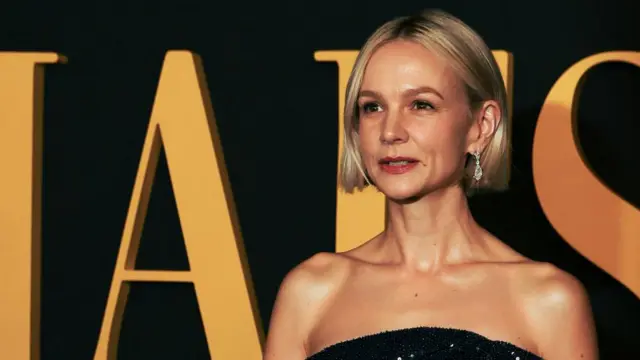 Carey Mulligan in front of a sign reading Maestro