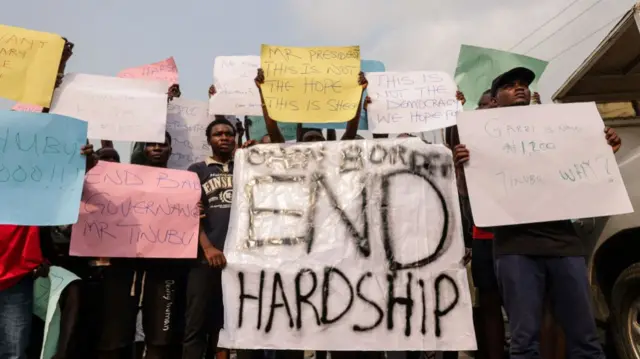 Demonstrators hold placards during a protest against the hike in price and hard living conditions in Ibadan