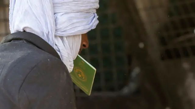 An immigrant from Mauritania enters a transport vehicle from the U.S.-Mexico border on December 07, 2023