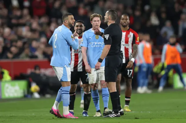 Kyle Walker of Manchester City complains to referee Jarred Gillett about Neal Maupay of Brentford