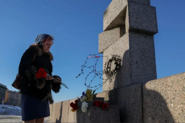 People lay flowers to honour the memory of Alexei Navalny in St Petersburg