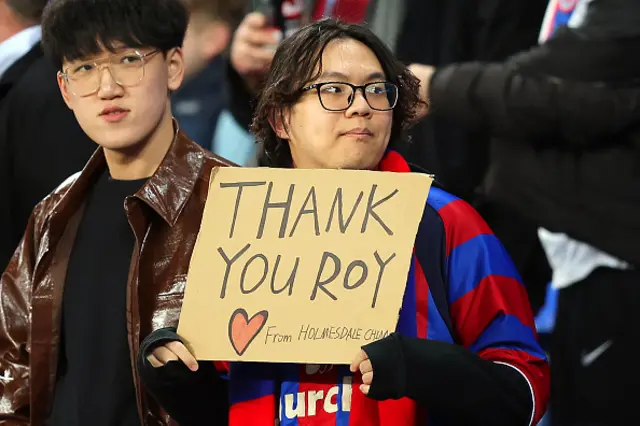 A fan of Crystal Palace holds a sign in support of previous manager Roy Hodgson