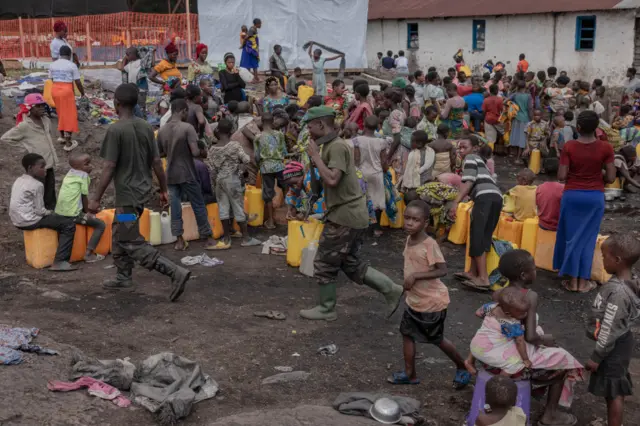 Congolese army soldiers walk among the displaced Congolese women and children at the Bulengo camp a few kilometres from the centre of Goma, eastern Democratic Republic of Congo, on February 16, 2024