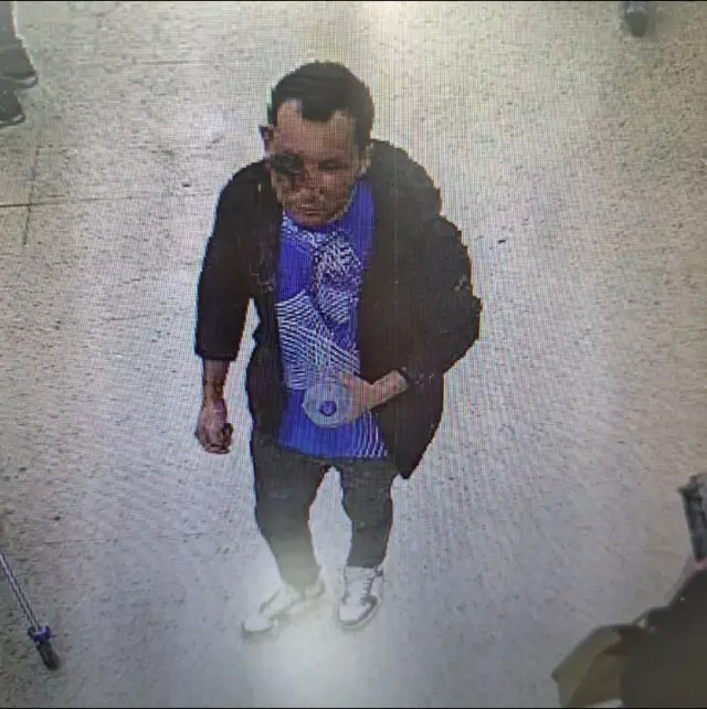 CCTV still of Ezedi, with an injured, bloodied right side of his face.