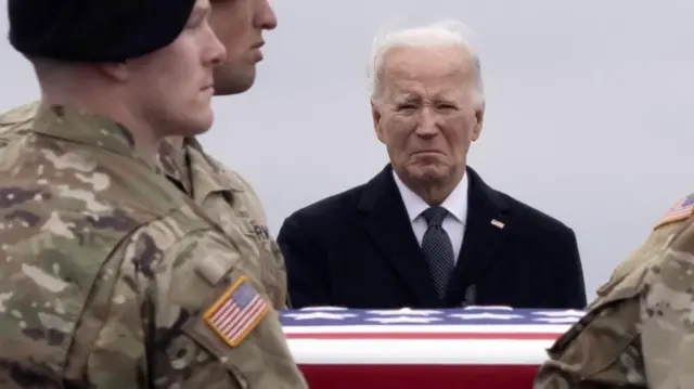 Joe Biden looks on as the coffin of one of the US soldiers killed in the attack on the Tower 22 is carried in front of him