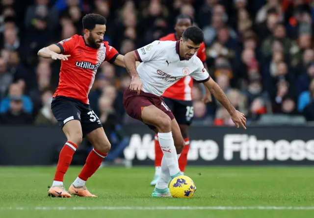 Rodri holds off a challenge from Andros Townsend.