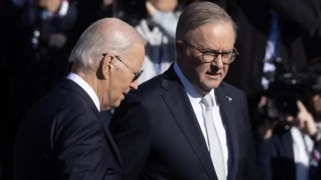 Australia's Prime Minister Anthony Albanese stands close to Biden as reporters photograph them