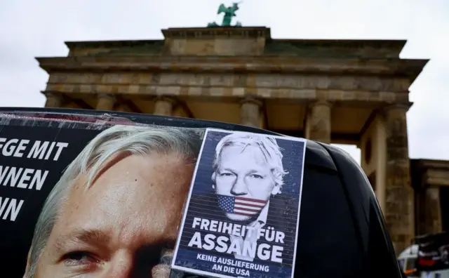 A banner by the Brandenburg Gate reads "Freedom for Assange" in German