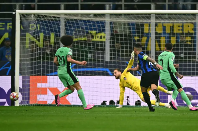 Martinez drags his shot wide as Oblak and Gimenez watch on.