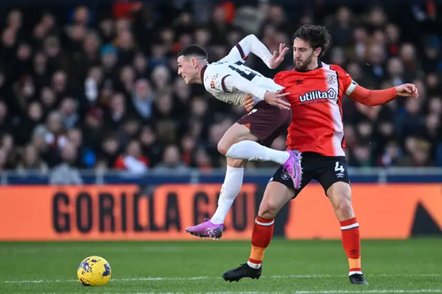 Foden dribbles past the oncoming challenge of Lockyer in midfield.