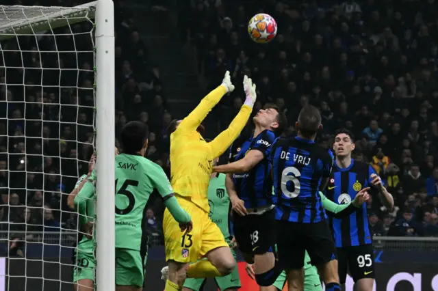 Atletico keeper Oblak reaches for the ball above a packed penalty area,.