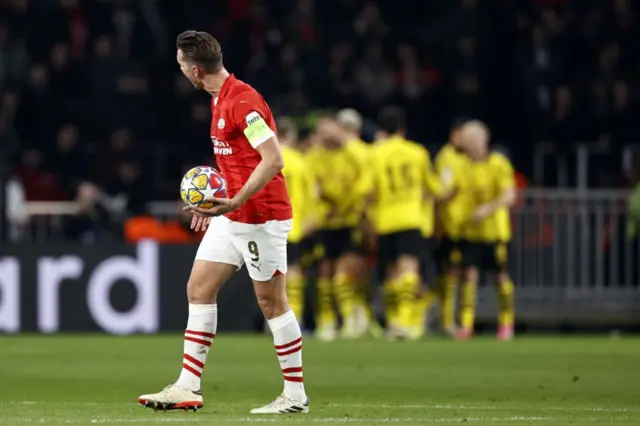 De Jong carries the ball back to kick off as Dortmund celebrate behind him.