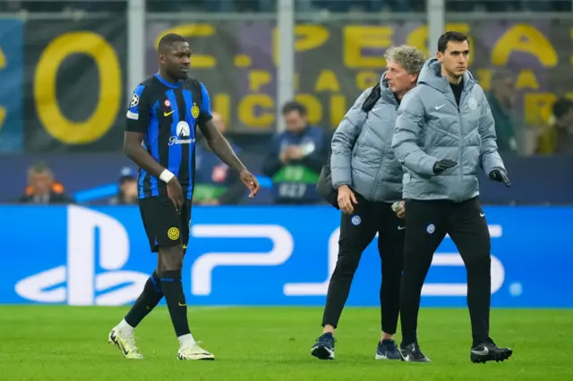 Thuram walks off at half time flanked by Inter physios.