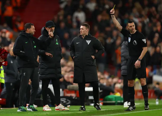 Goalkeeping coach John Achterberg is shown a yellow card