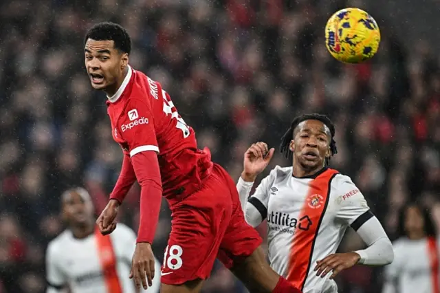 Cody Gakpo (L) and Luton Town's Gabriel Osho eye the ball