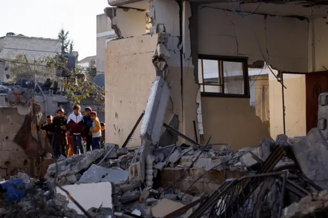 Palestinian children gather at the site of an Israeli strike on a house in Rafah