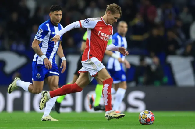 Odegaard is tracked by Evanilson in midfield.