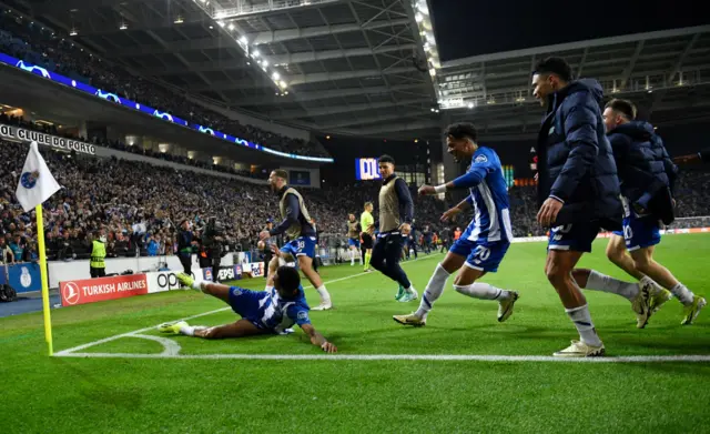 Galeno is chased by teammates as he sldies to the corner flag to celebrate.