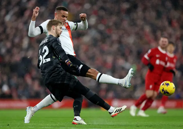 Caoimhin Kelleher of Liverpool clears the ball whilst under pressure from Carlton Morris