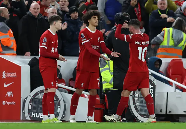 James McConnell of Liverpool looks on as Jayden Danns shakes hands with Alexis Mac Allister