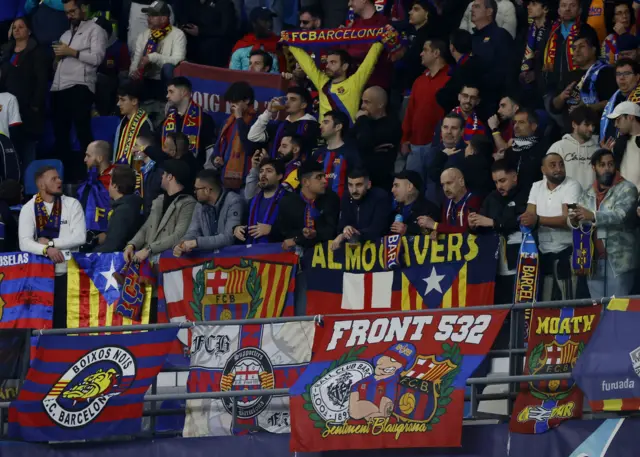 Barcelona fans hold up scarves in the away end in naples.